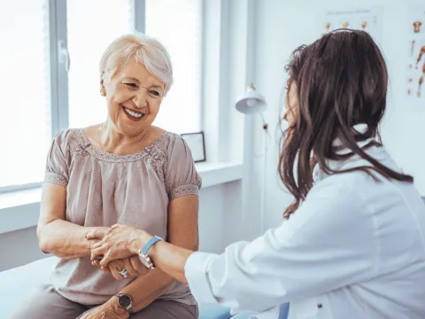 A Provider Holds a Smiling Patient's Hand