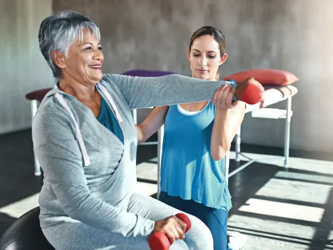 A woman lifts weights to help improve bone density and fight osteoporosis