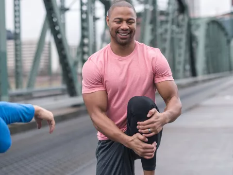 A man does a proper warm up to avoid injury.