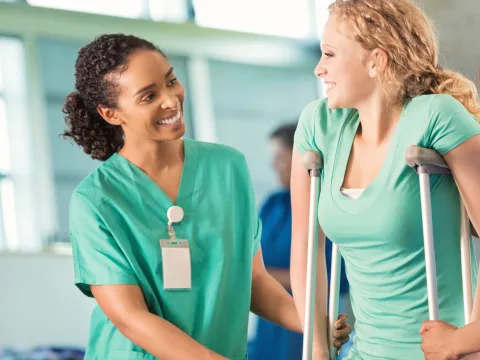 A woman talks with her physical therapist about her next steps once she's off crutches.