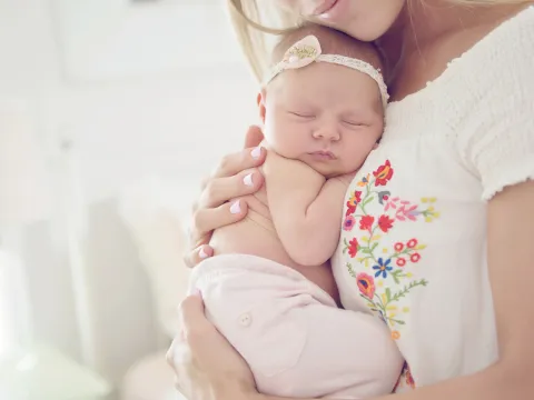 Mother holding baby to her chest.