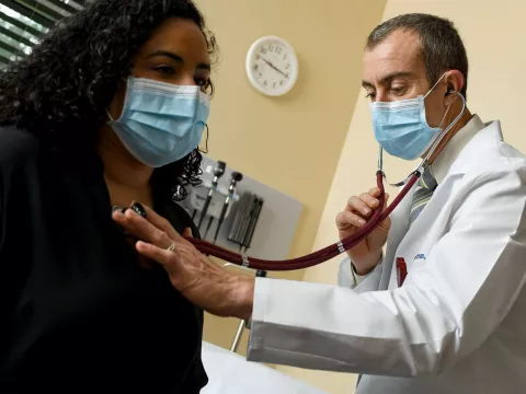 Doctor checking heart on patient