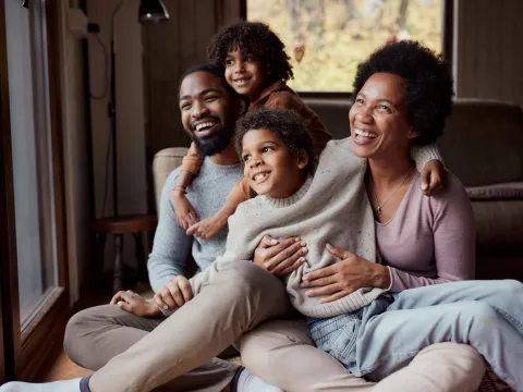 A happy African-American family looking out the window