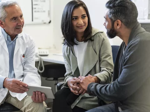 A couple discusses their care with their doctor.