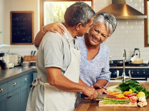 A couple prepares a meal full of vegetables.