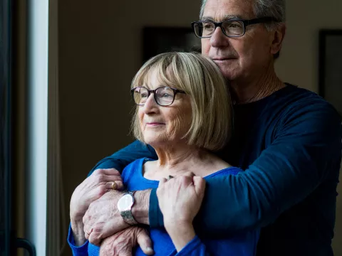 Husband holds her wife from behind