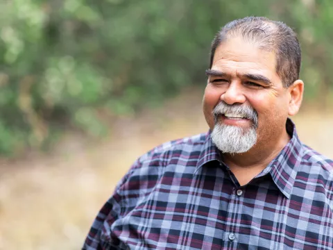 A mature man smiling and outdoors