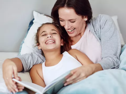 A mom reads her daughter a bedtime story.