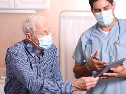A man having a safe visit with his doctor. 