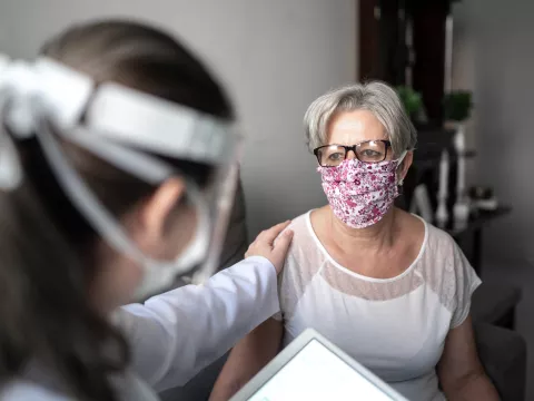 A physician reassuring her patient while they are talking