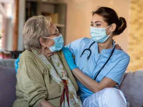 Ederly woman with care specialist wearing face masks