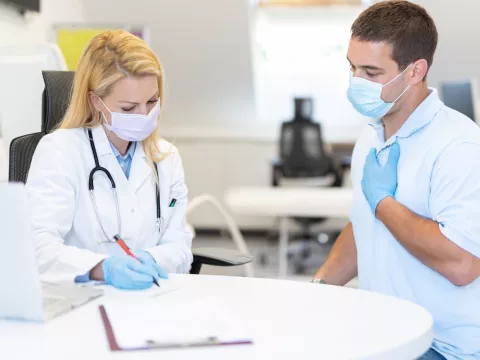 A man discussing his symptoms with his doctor.