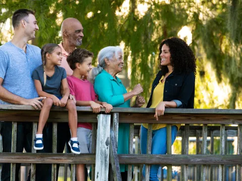 A Hispanic Family Chats on a Bridge in a Park