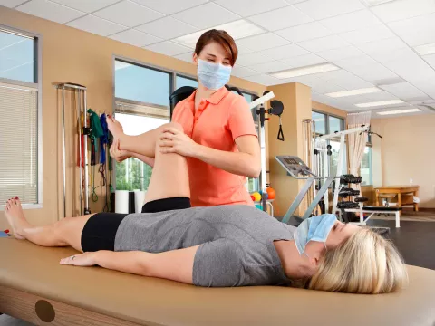 A woman getting physical therapy done by a female specialist