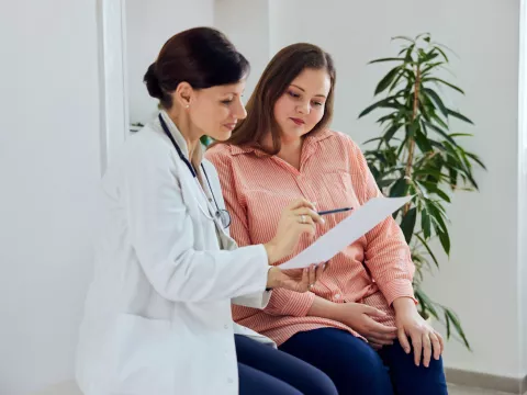 A woman and her healthcare provider looking at a document together.